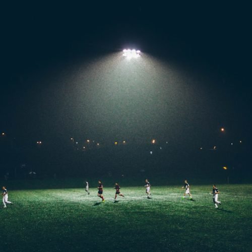 Estádio de futebol iluminado à noite em clima de decisão